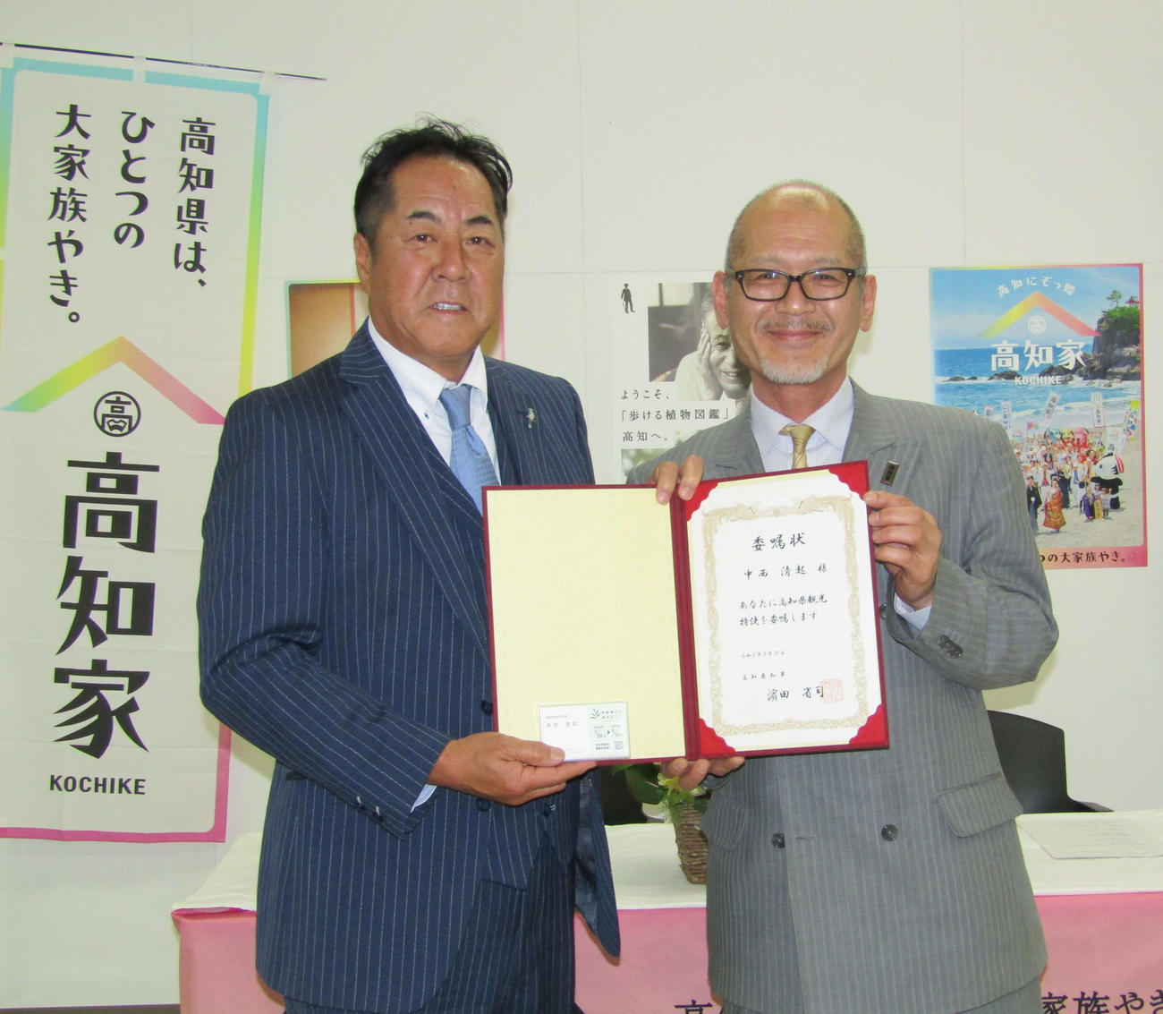 浜渦高知県大阪事務所長（右）から高知県観光特使委嘱状と名刺を受け取り笑顔を見せる中西清起氏（撮影・高垣誠）