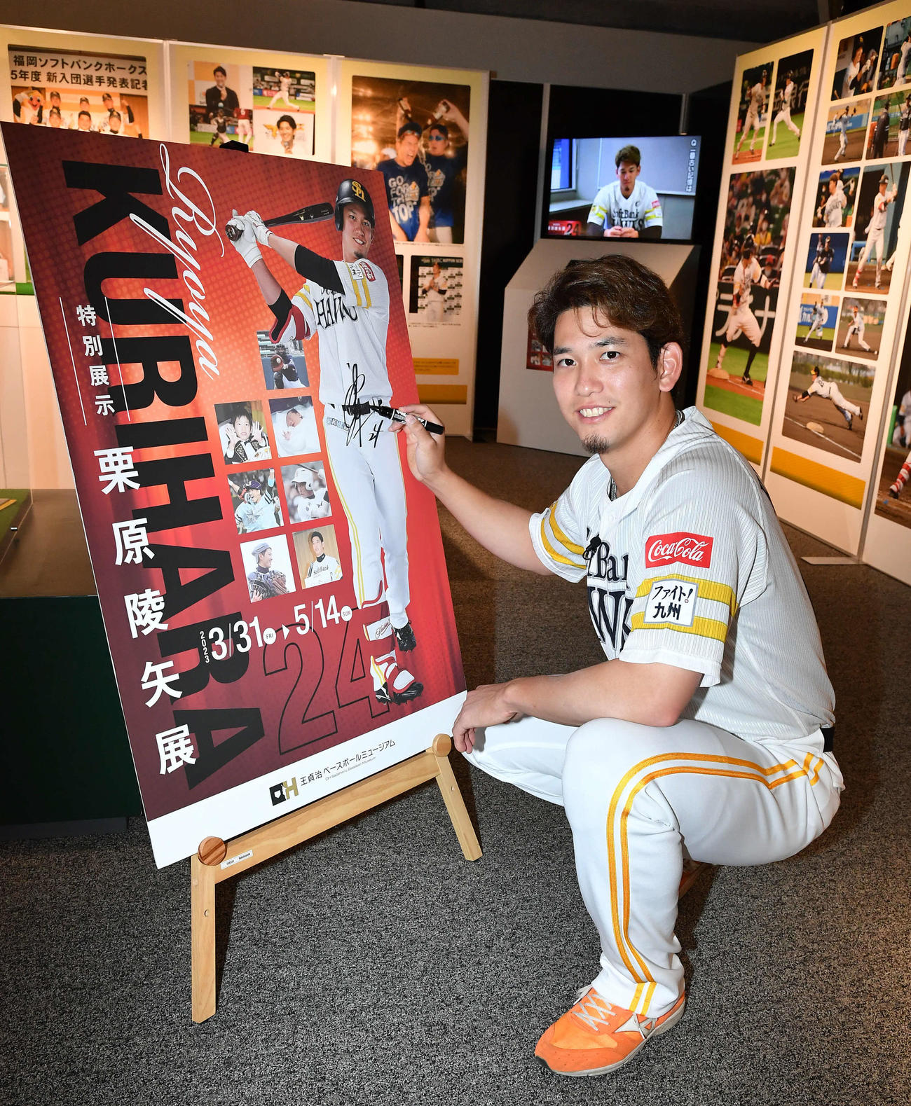 王貞治ベースボールミュージアム内で開催される特別展示「栗原陵矢展」を内覧し、ボードにサインを書き入れる栗原（撮影・岩下翔太）
