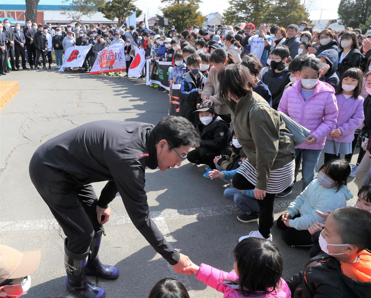 多くの栗山町民に出迎えられた侍ジャパンの栗山監督は地元の子どもたちと握手する（撮影・黒川智章）