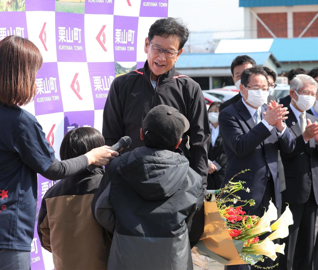 栗山町に帰町した侍ジャパンの栗山監督は地元の子どもたちから花束を受け取る（撮影・黒川智章）