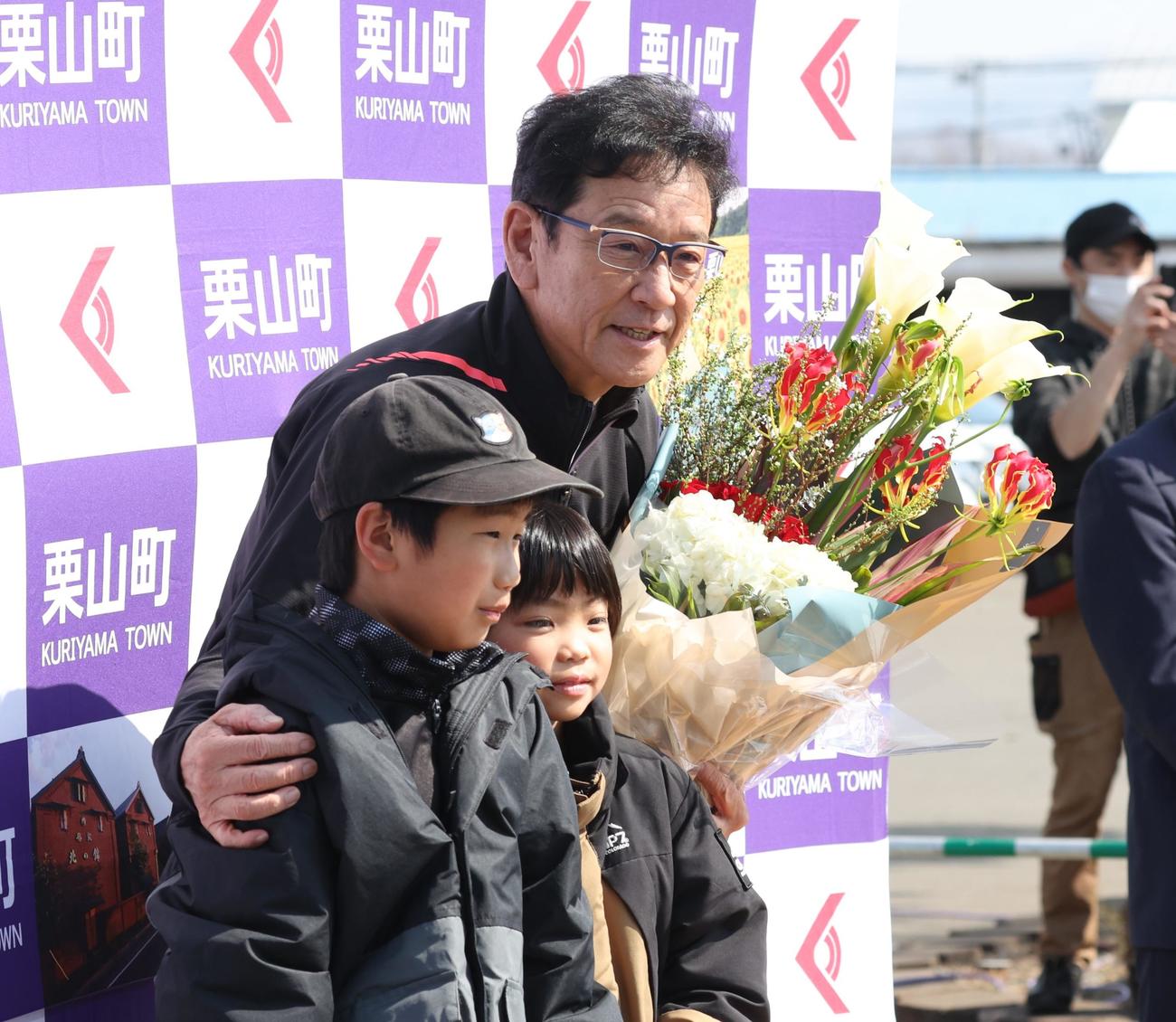 栗山町に帰町した侍ジャパンの栗山監督は地元の子どもたちから花束を受け取り記念撮影（撮影・黒川智章）