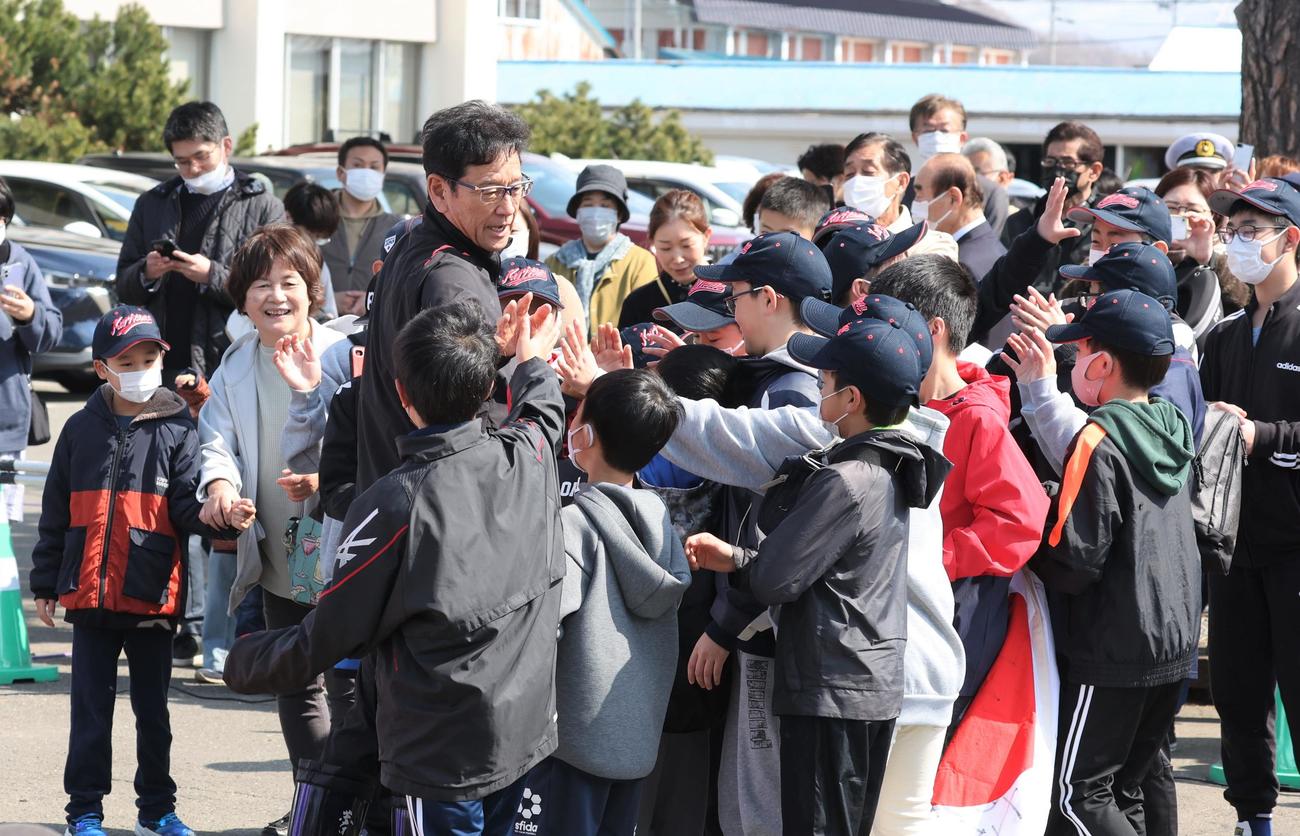 多くの栗山町民に出迎えられた侍ジャパンの栗山監督は地元の子どもたちとハイタッチする（撮影・黒川智章）