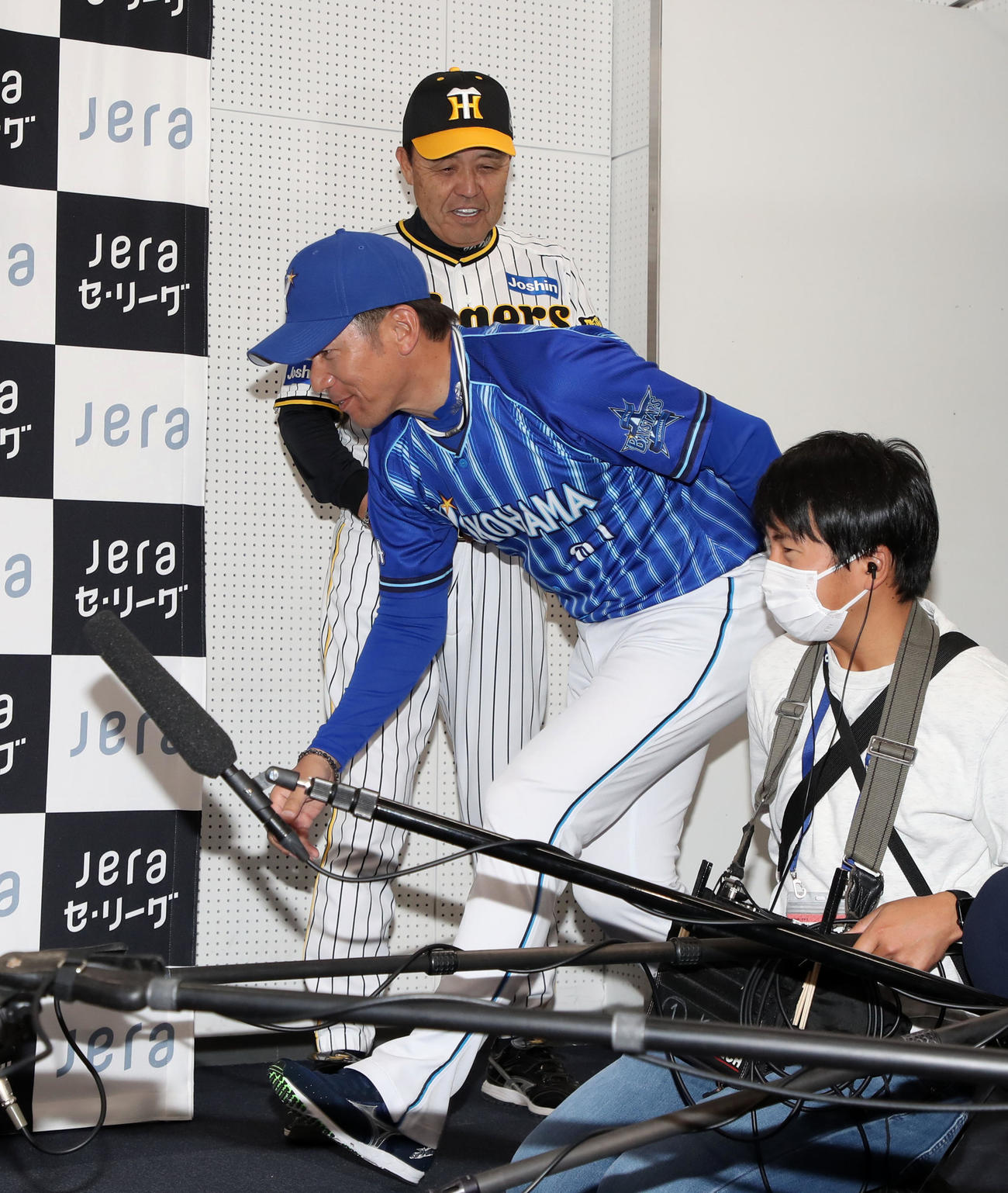 監督会見場へ先に入っていた阪神岡田監督の前を手刀を切って通るDeNA三浦監督（撮影・加藤哉）