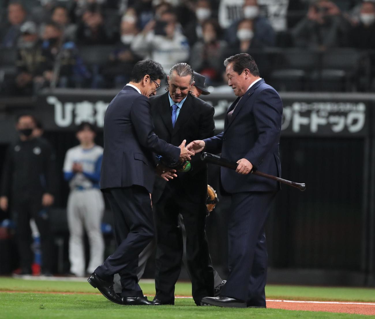 日本ハム対楽天　始球式に登場し握手する日本ハム歴代監督。左から栗山氏、ヒルマン氏、梨田氏（撮影・黒川智章）