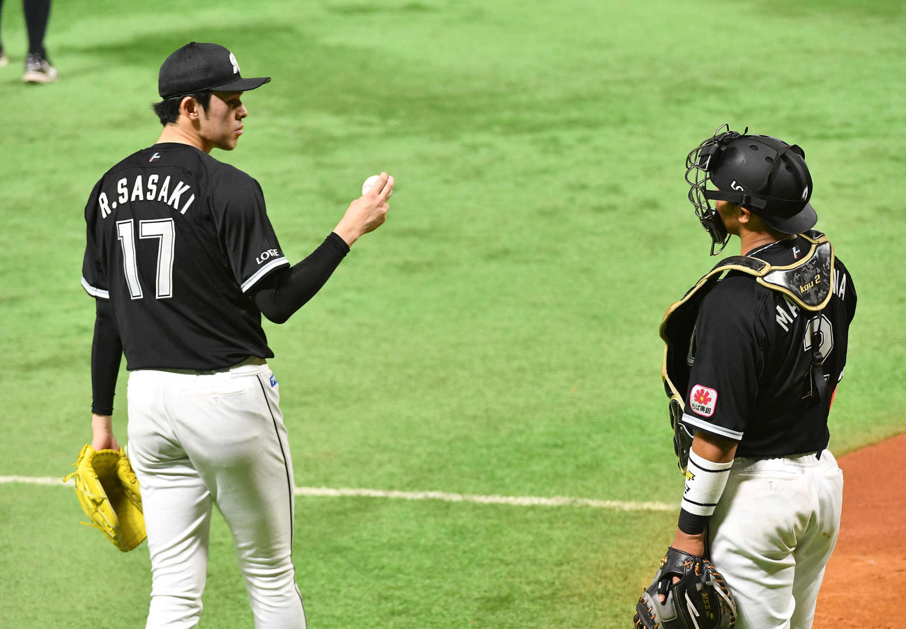 シート打撃のインターバルを終え、松川（右）と話しながら2度目のマウンドに向かう佐々木朗（撮影・岩下翔太）