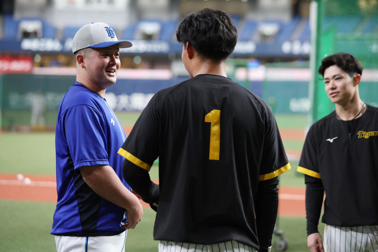 阪神対DeNA　試合前練習で阪神森下（中央）、中野（右）と言葉を交わすDeNA牧（撮影・前田充）