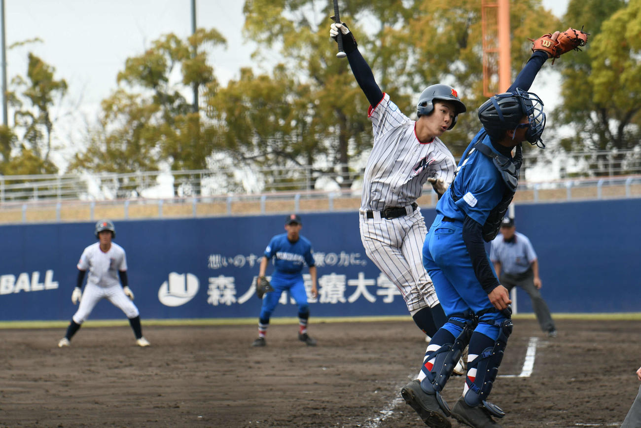 東練馬対中本牧　東練馬の戸嶋健太郎はスクイズを外されたが暴投となり勝ち越し。捕手は浅沼慈道（撮影・久我悟）