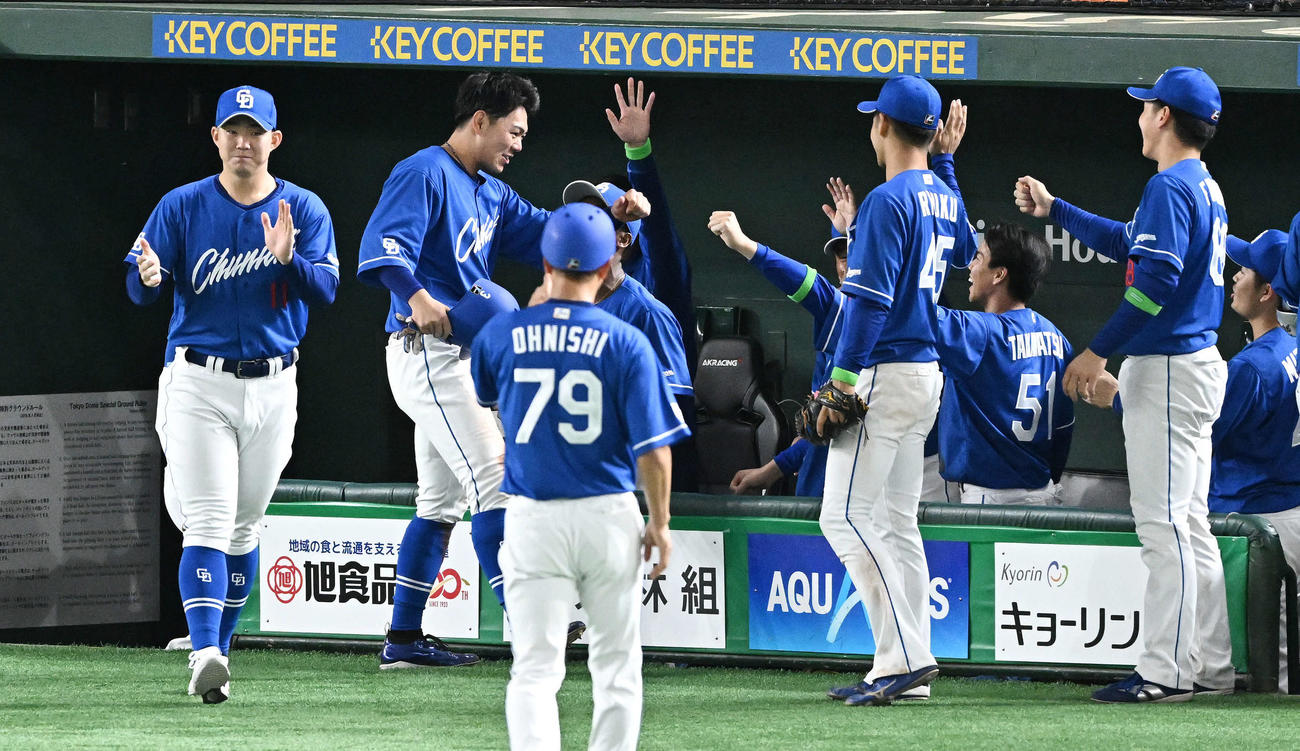 巨人対中日　9回表に2点適時二塁打を放った中日高橋周（左から2人目）はベンチへ戻りチームメートから祝福される（撮影・滝沢徹郎）