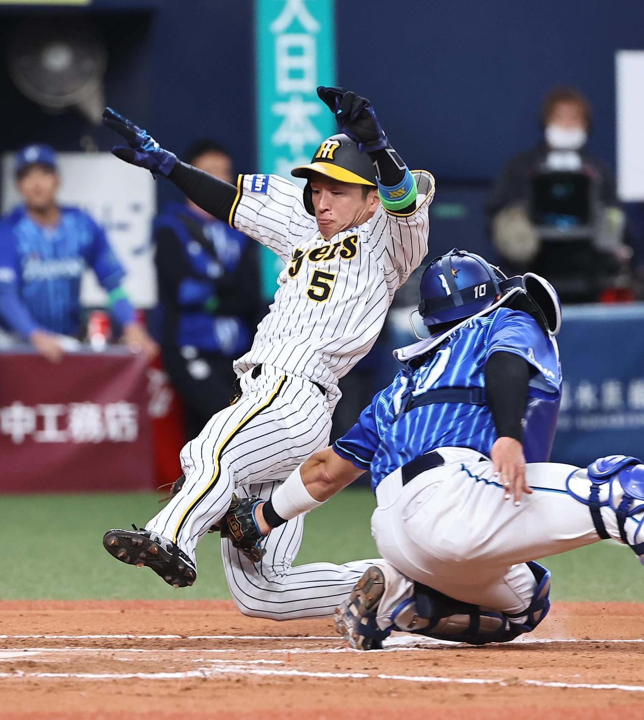 阪神対DeNA 7回裏阪神1死二塁、近本（左）はノイジーの中前打で生還を狙うも憤死する。捕手戸柱（撮影・上田博志）