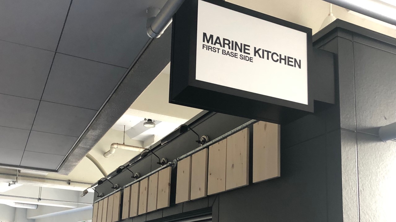 ZOZOマリンスタジアムの飲食店新店舗「MARINE KITCHEN FIRST BASE SIDE」の看板（球団提供）