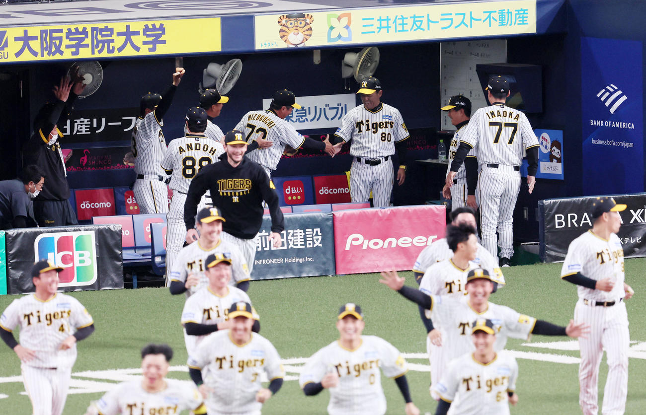 阪神対DeNA 12回裏阪神2死満塁、近本のサヨナラ中前適時打で勝利し笑顔で握手する岡田監督（撮影・加藤哉）