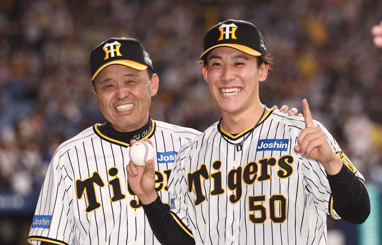 プロ初勝利を挙げた富田（右）は、岡田監督と笑顔を見せる（撮影・上田博志）