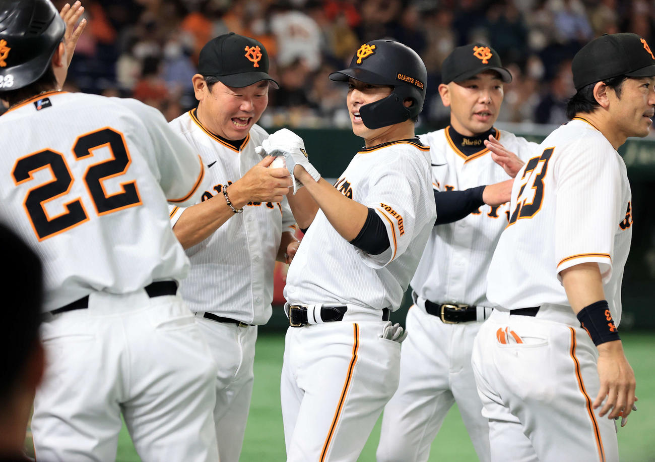 巨人対中日　7回裏巨人1死満塁、長野（中央）は勝ち越し左適時打を放ち、大久保打撃チーフコーチらに迎えられ笑顔を見せる（撮影・浅見桂子）