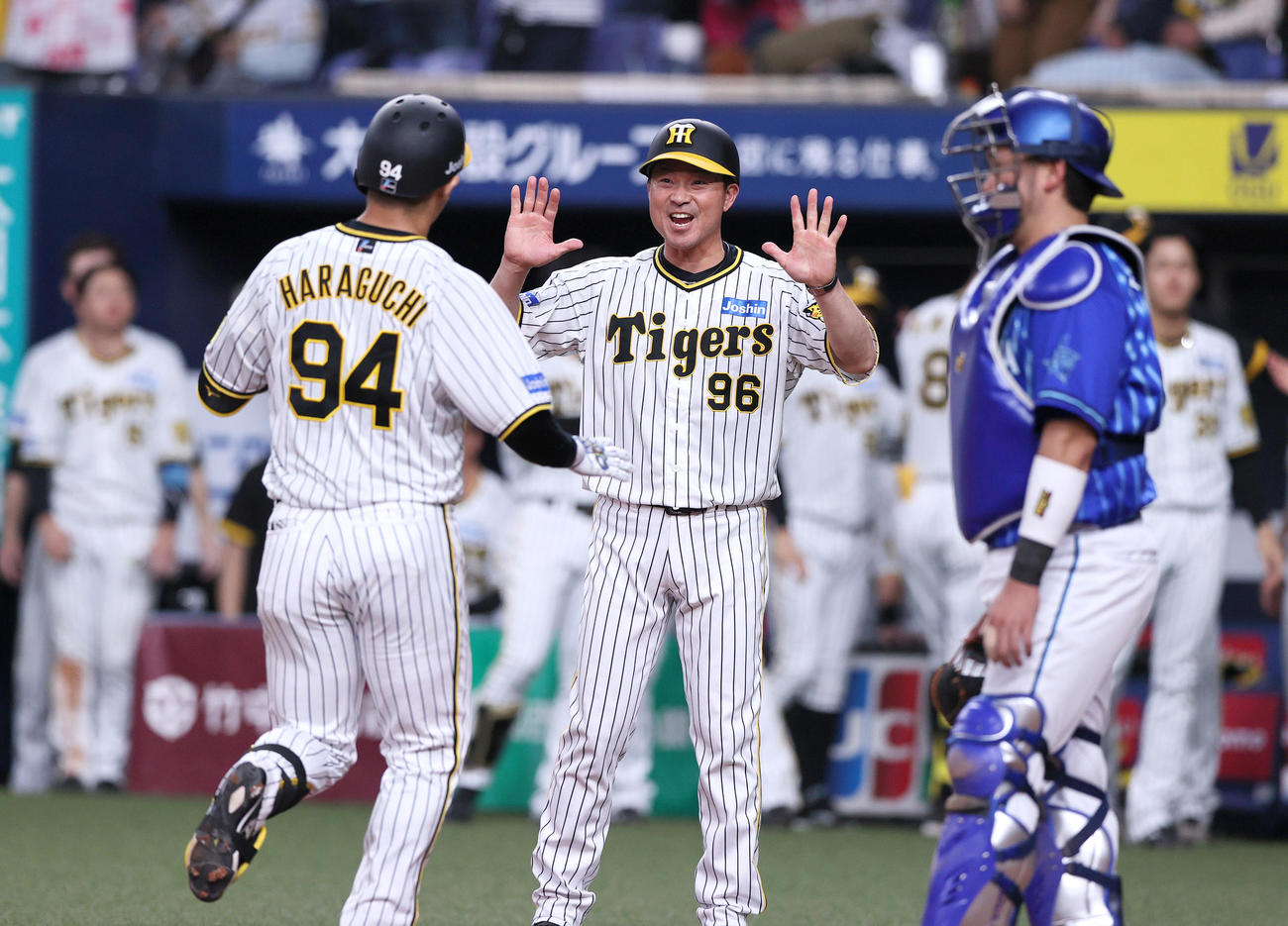 阪神対DeNA 8回裏阪神2死二塁、左越え2点本塁打を放った代打原口（手前）を出迎える筒井外野守備走塁コーチ（中央）（撮影・上山淳一）