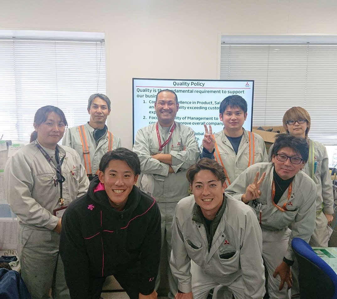 職場の同僚と記念撮影をする阪神富田（最前列左）と馬場一平さん（最後列左から2番目）（三菱自動車工業(株)提供）