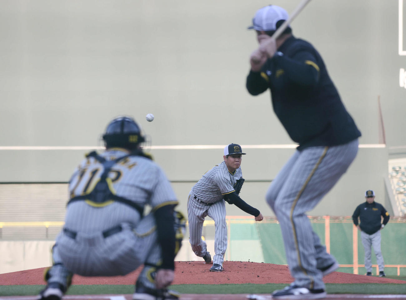 マウンドで打者を立たせて投球練習をする西勇。右後ろは岡田監督（撮影・加藤孝規）