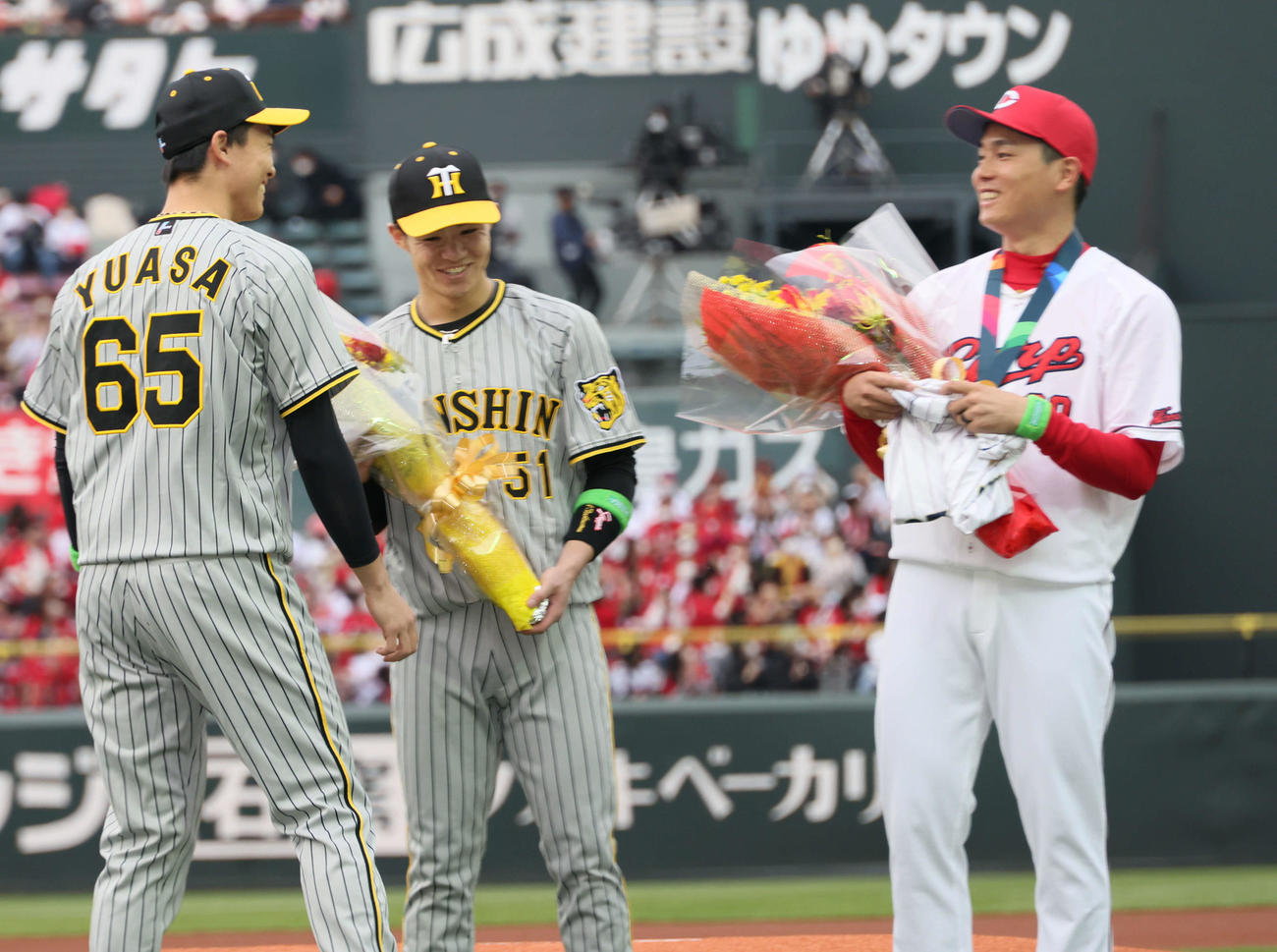 広島対阪神　栗林（右）に選手のサイン入りユニホームを渡す湯浅。中央は中野（撮影・加藤孝規）