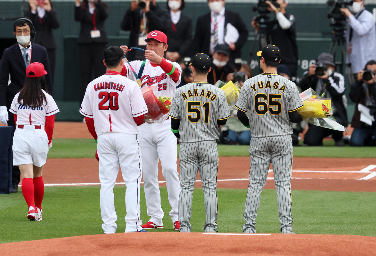 広島対阪神　新井監督からWBCの優勝メダルをクビにかけてもらう栗林（左）。中央は中野、右は湯浅（撮影・加藤哉）