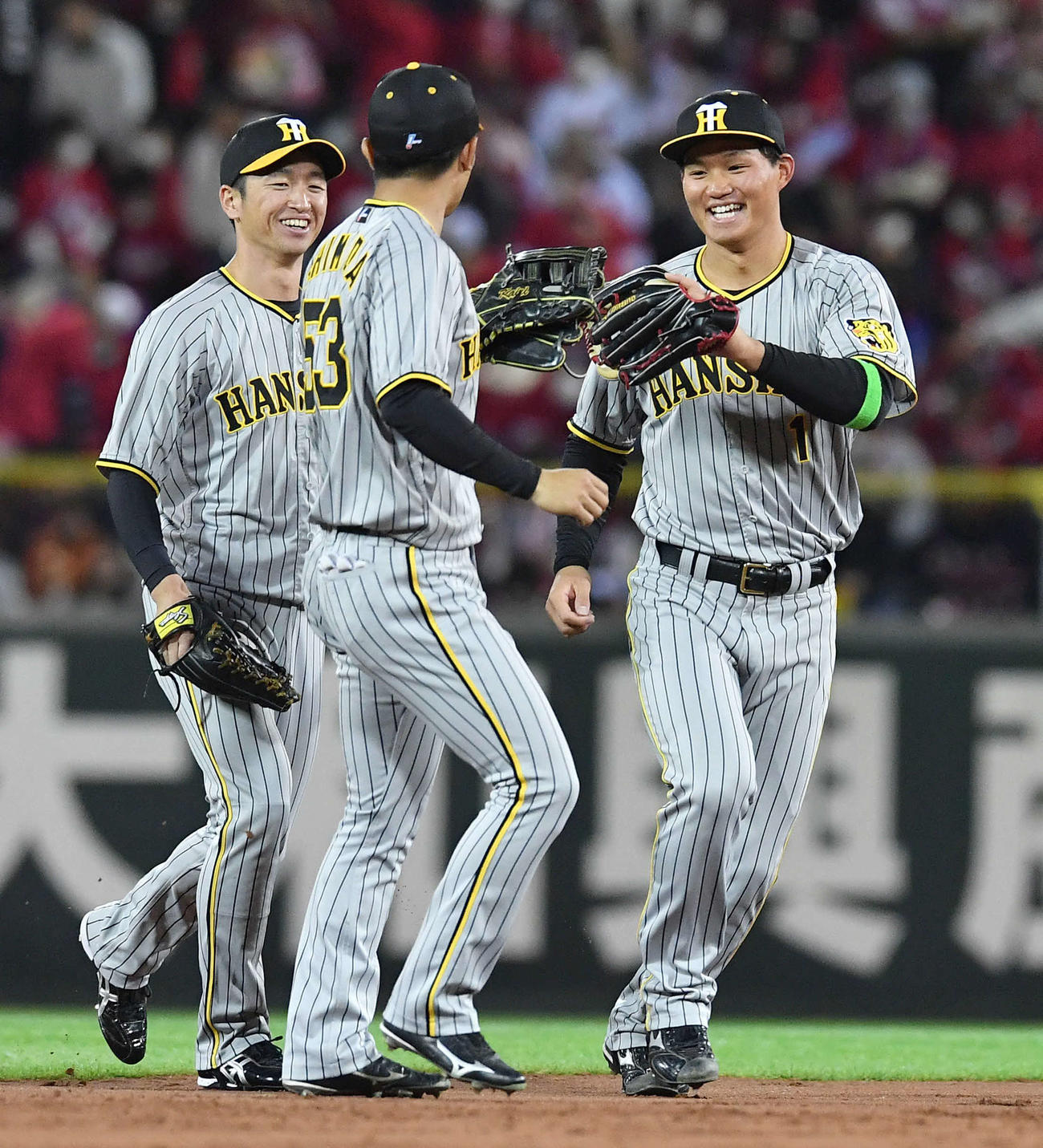 広島対阪神　広島に勝利し近本（左）、島田（中央）とタッチを交わす森下（撮影・岩下翔太）