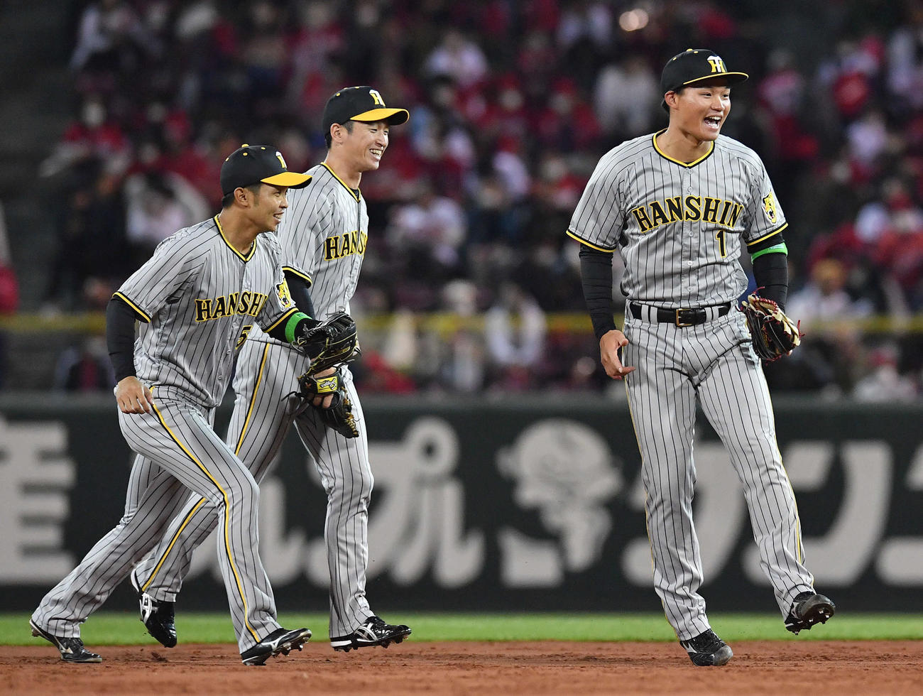 広島対阪神　広島に勝利し、ナインの集まるマウンドに笑顔で向かう、左から島田、近本、森下（撮影・岩下翔太）