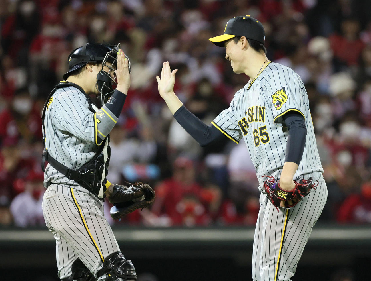 広島対阪神　最後を締めた湯浅（右）は梅野とハイタッチ（撮影・加藤孝規）