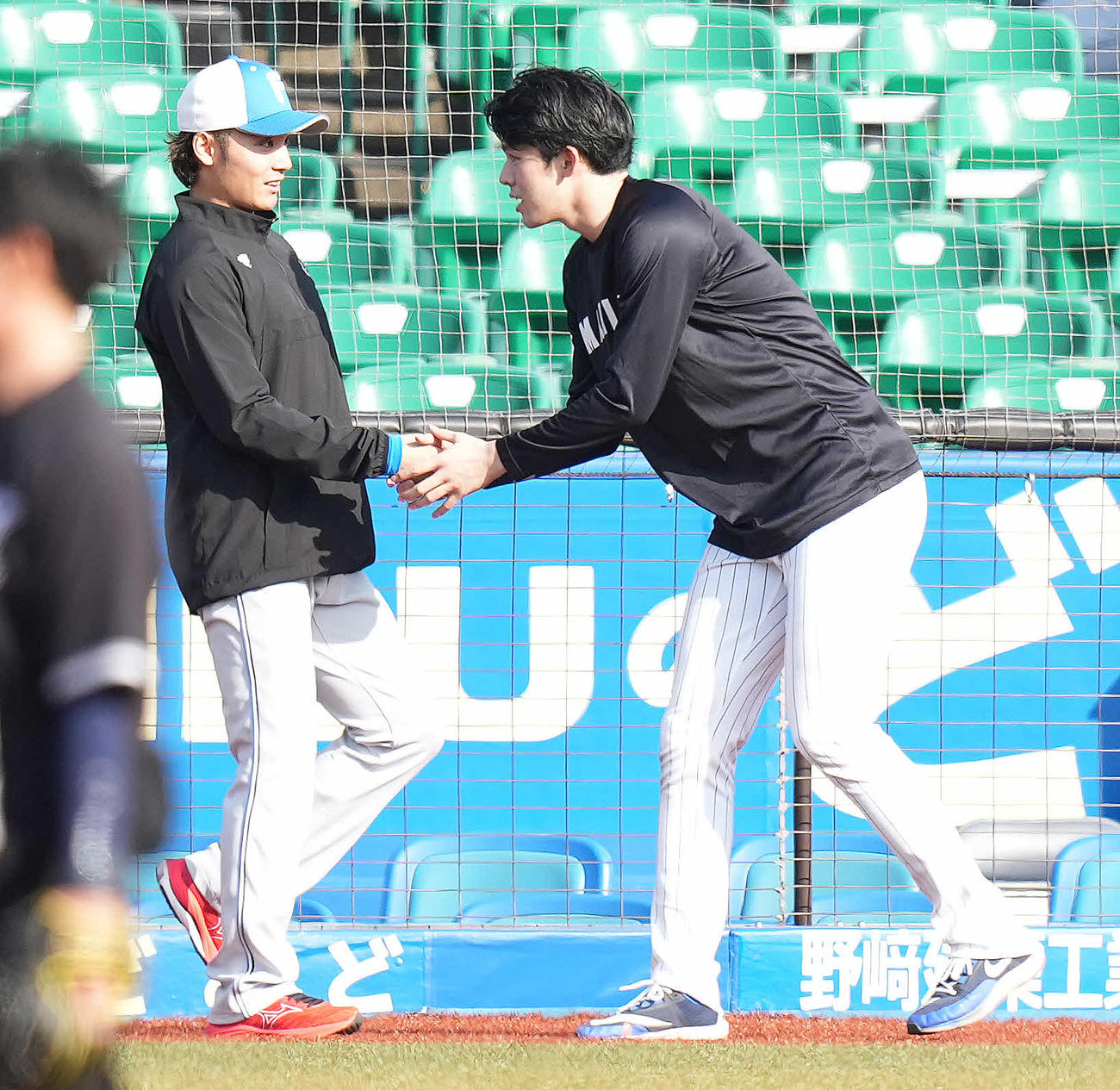 ロッテ対日本ハム　試合前練習で日本ハム伊藤（左）にあいさつするロッテ佐々木朗（2023年4月4日撮影）