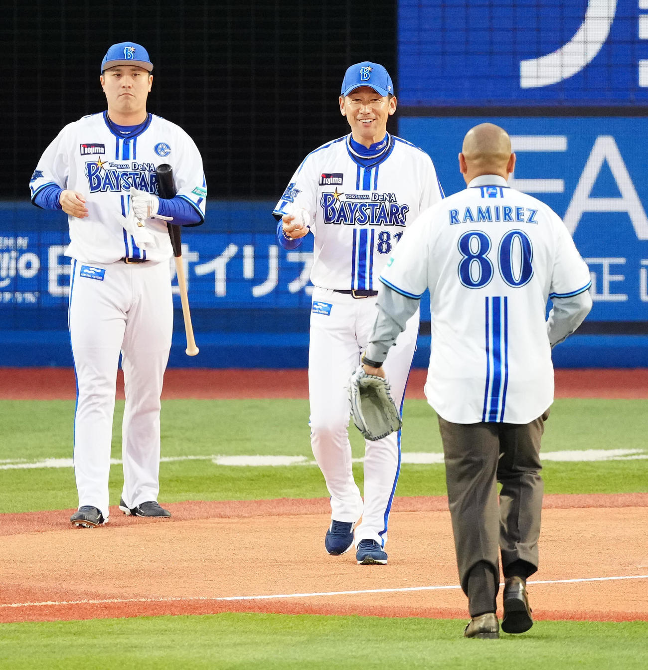 DeNA対巨人　試合前、セレモニアルピッチでラミレス氏（手前）のボールを捕球し、笑顔を見せるDeNA三浦監督。左は打者佐野（撮影・江口和貴）