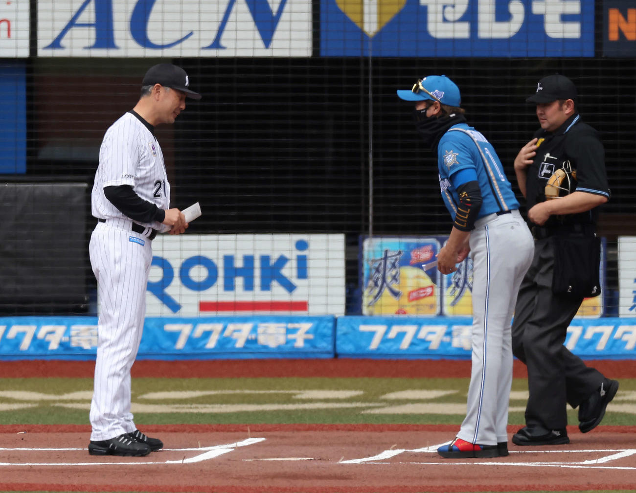 ロッテ対日本ハム　試合開始前、メンバー表交換する吉井監督（左）と日本ハム新庄監督（撮影・河田真司）