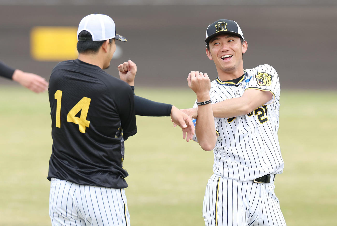 ウォーミングアップ中、阪神岩貞（左）と談笑する伊藤将（撮影・前田充）