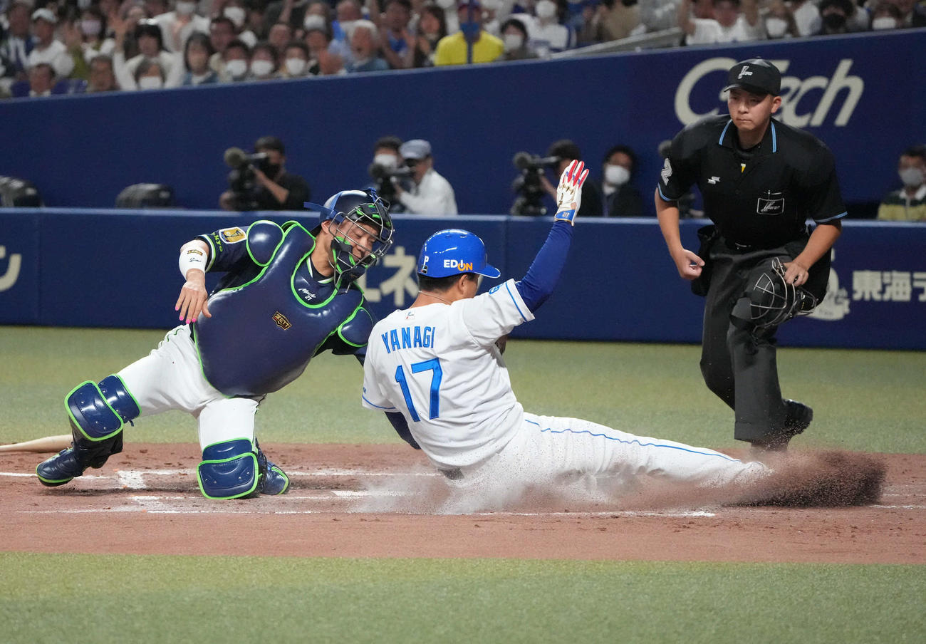 中日対ヤクルト　3回裏中日2死二塁、大島の左前打で本塁突入するもタッチアウトの二塁走者柳（中央）。捕手中村（撮影・森本幸一）
