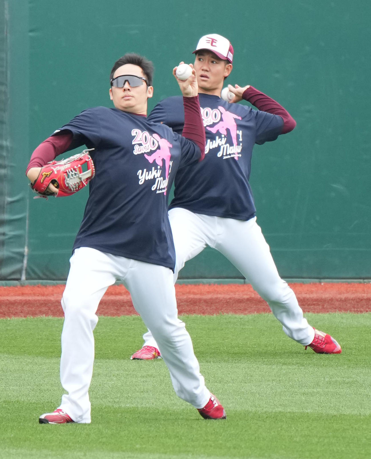 楽天対西武　前日の試合で史上最年少でプロ入り通算200セーブを達成した楽天松井裕は祝福するナインといっしょに記念Tシャツを着て試合前練習に臨む（撮影・小沢裕）