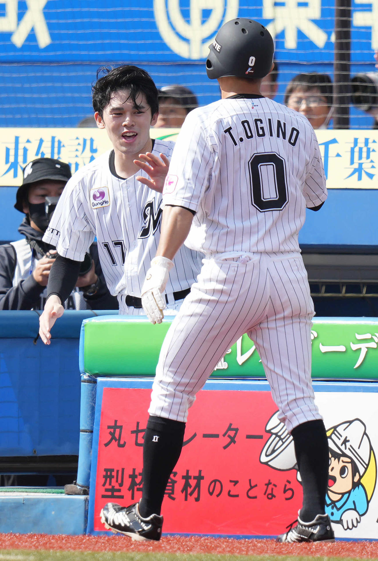 ロッテ対日本ハム　1回裏ロッテ1死二塁、中村奨の先制の中前適時打で生還した二塁走者荻野（右）を笑顔で迎える佐々木朗（撮影・鈴木みどり）
