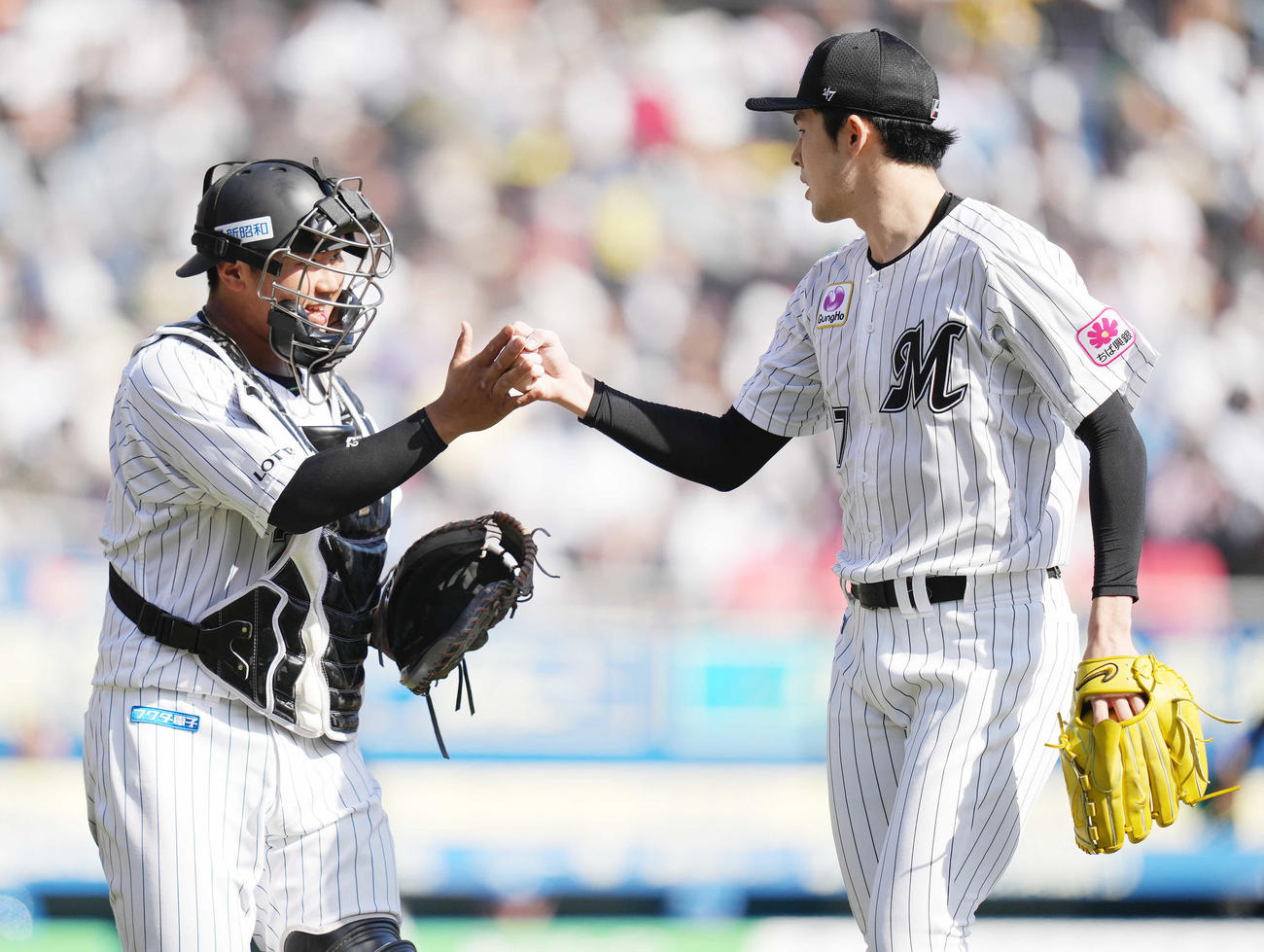 ロッテ対日本ハム　4回表日本ハム2死、野村を空振り三振に仕留め、松川（左）とタッチを交わす佐々木朗（撮影・鈴木みどり）