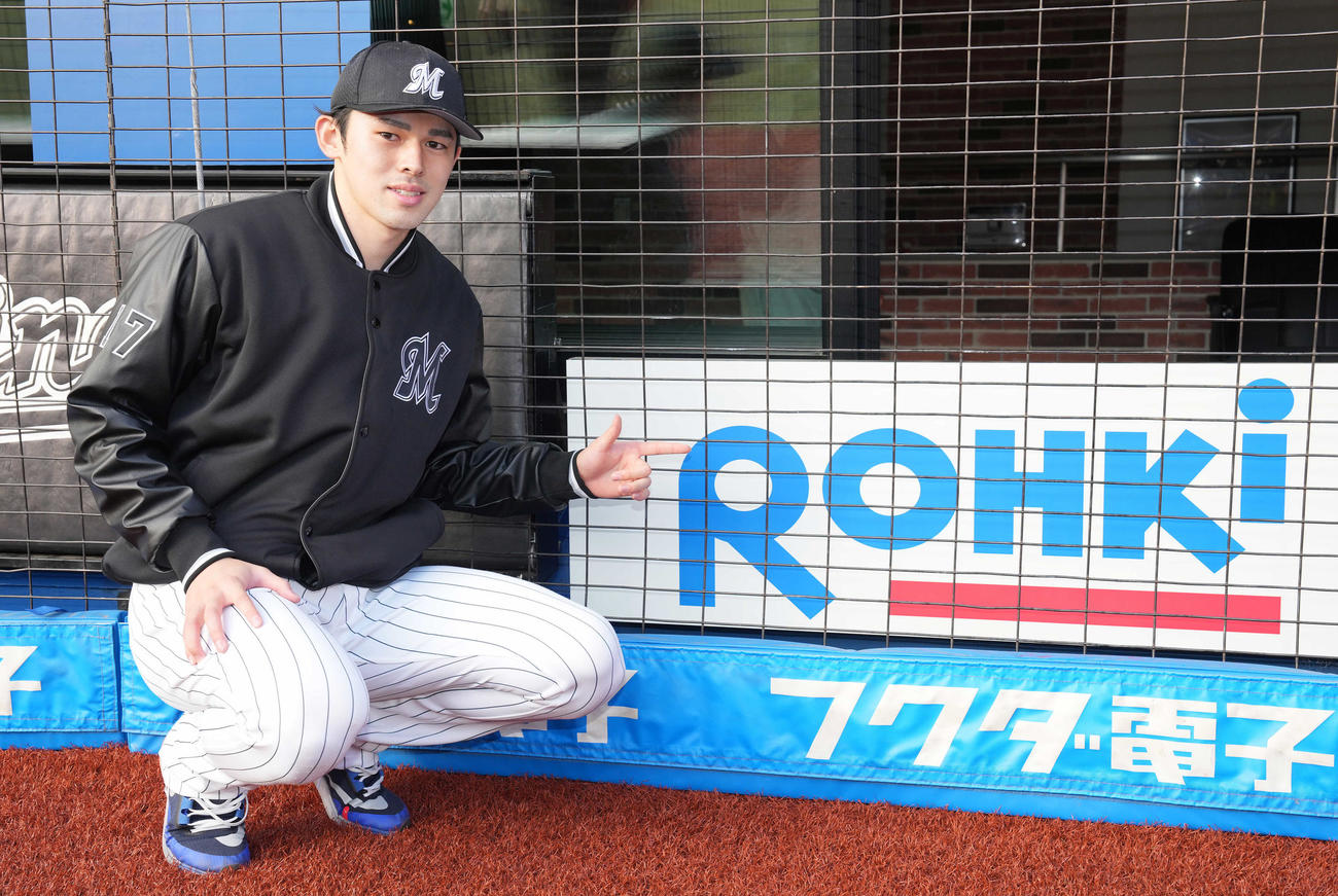ロッテ対日本ハム　特別仕様で「ROHKi」と表記されたロート製薬の広告の前で記念撮影するロッテ佐々木朗（撮影・鈴木みどり）