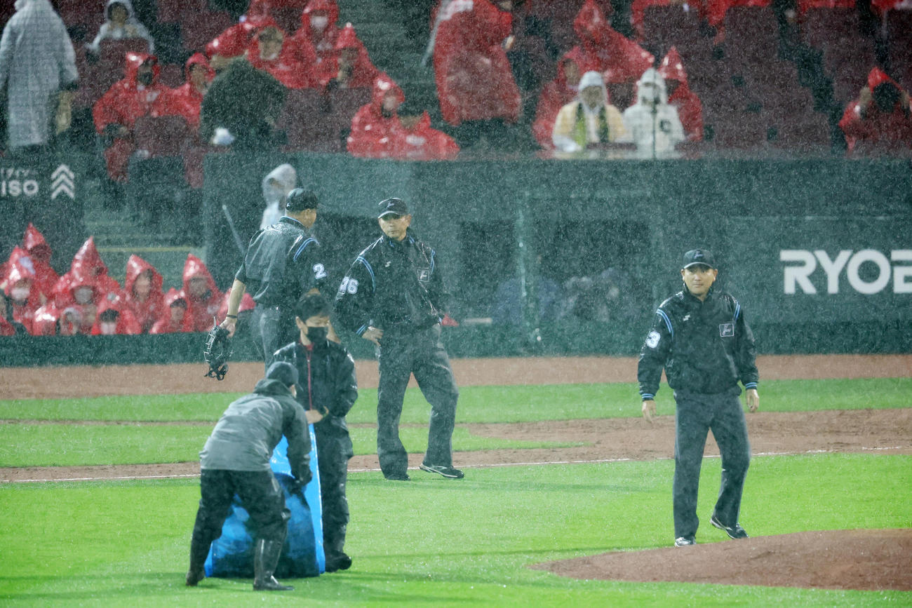 広島対阪神　6回表阪神無死、打者佐藤輝のとき降雨中断となり集まる審判団（撮影・加藤哉）