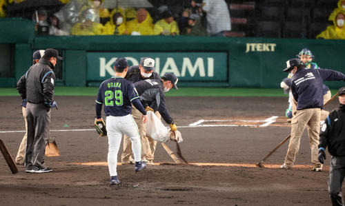 阪神対ヤクルト　1回裏阪神2死一塁、降雨中断明けマウンドに土を入れる阪神園芸の職員たち。投手は小川（撮影・加藤哉）