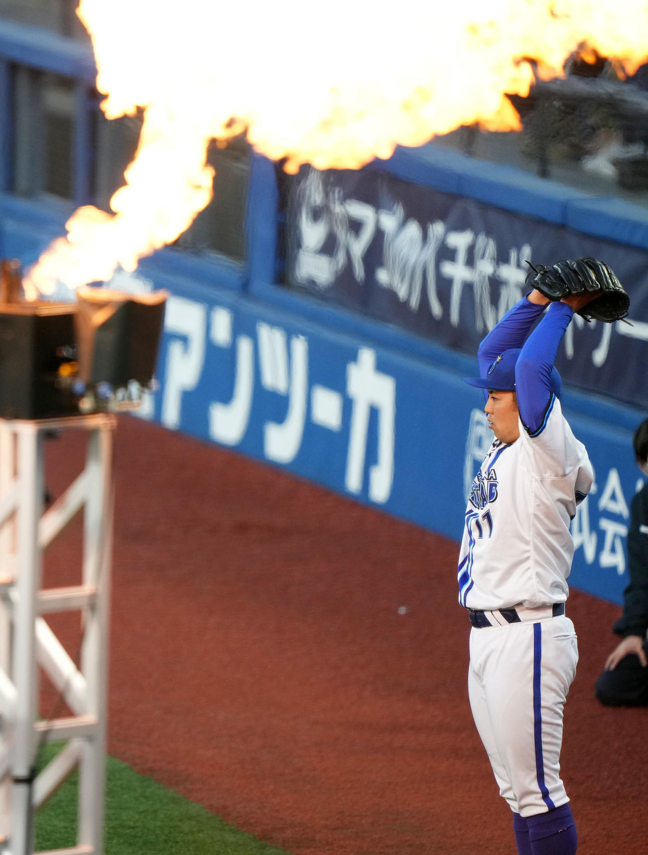DeNA対巨人　炎が立ち上る中、キャッチボールをするDeNA東（撮影・横山健太）