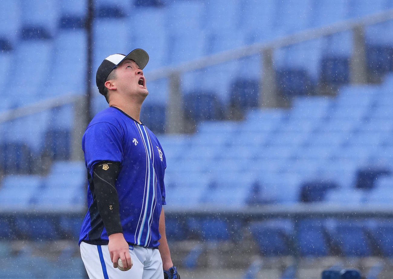 DeNA対中日　DeNA牧は試合前練習中、雨足が強くなるのを確認しこの表情（撮影・垰建太）