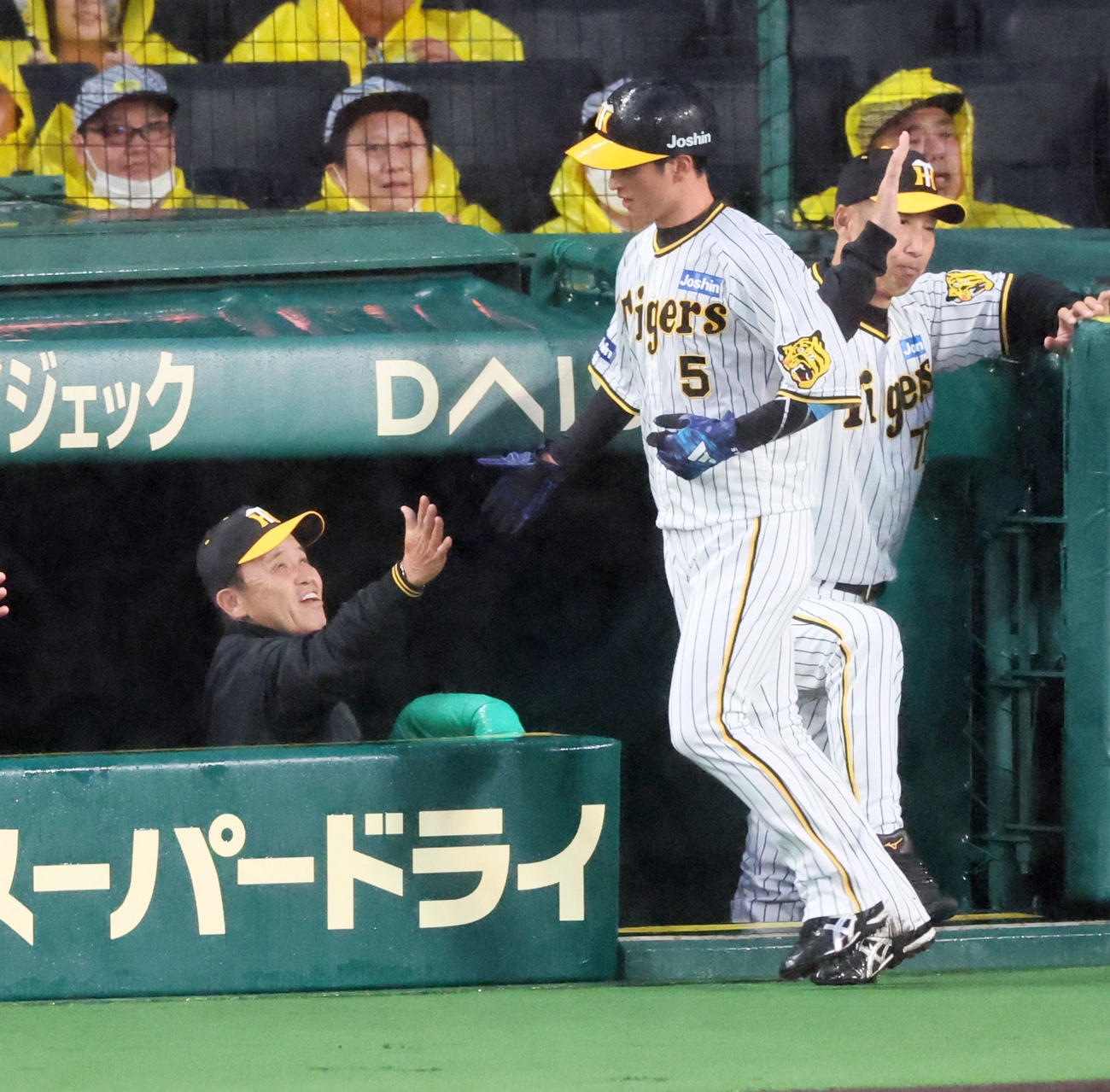 阪神対ヤクルト　1回裏阪神無死三塁、三塁走者近本は中野の中犠飛で生還しベンチの岡田監督（右）とタッチ（撮影・加藤哉）