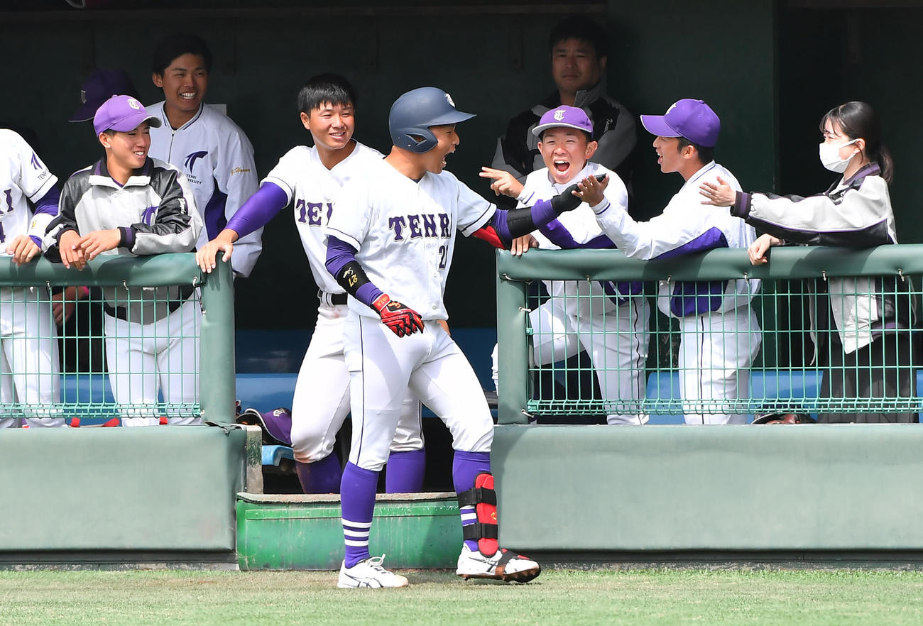 甲南大対天理大　5回裏天理大1死二、三塁、三塁走者の生還させる遊ゴロを放った小林（中央）はベンチ前で出迎えを受ける（撮影・清水貴仁）