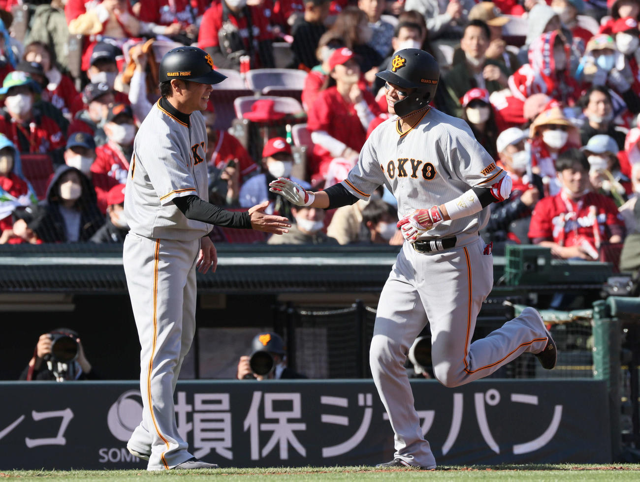 広島対巨人　7回表巨人無死、中越えソロ本塁打を放った坂本（右）は亀井コーチに迎えられる（撮影・加藤孝規）