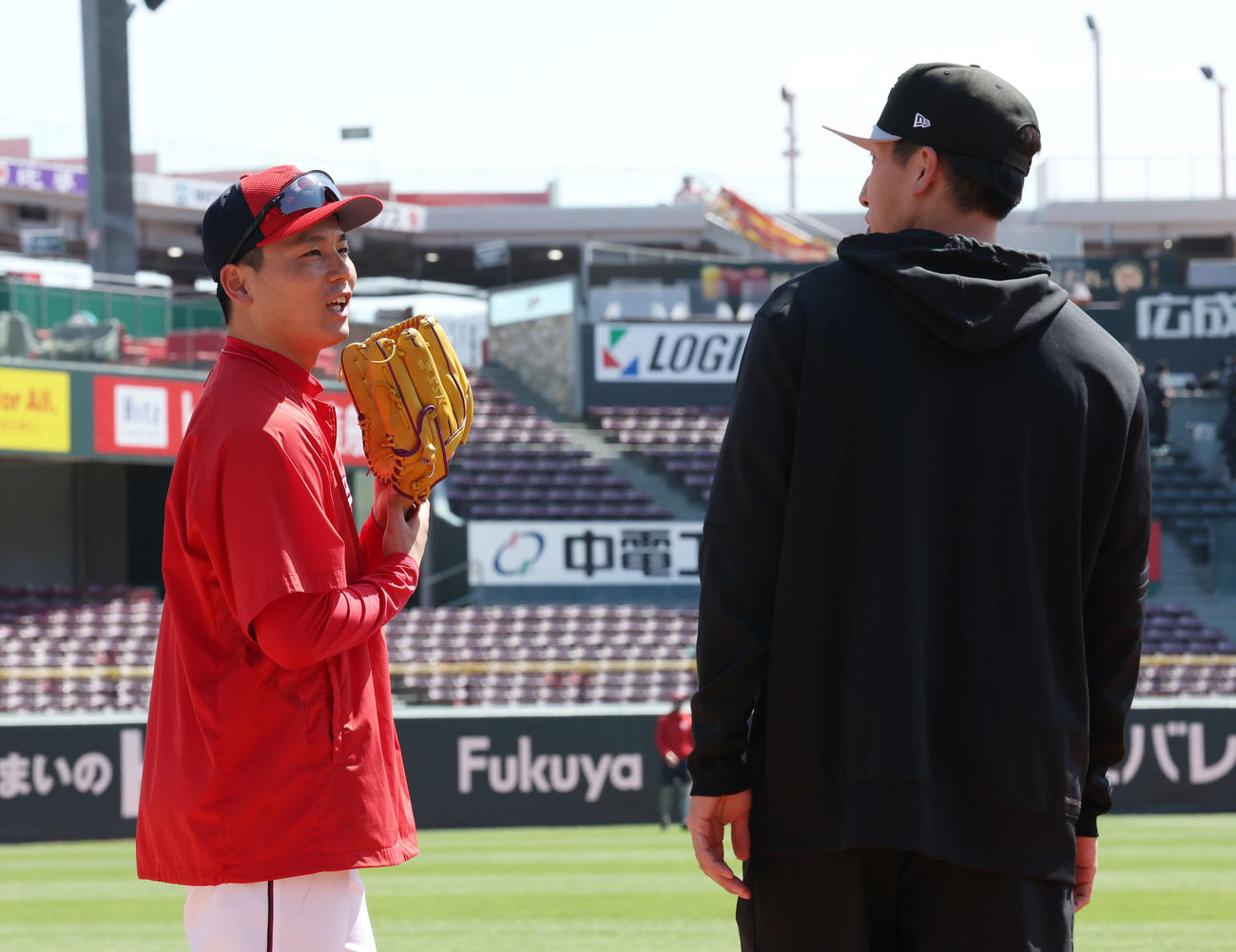 広島対巨人　試合前練習で会話する広島栗林（左）と巨人大勢（撮影・宮地輝）