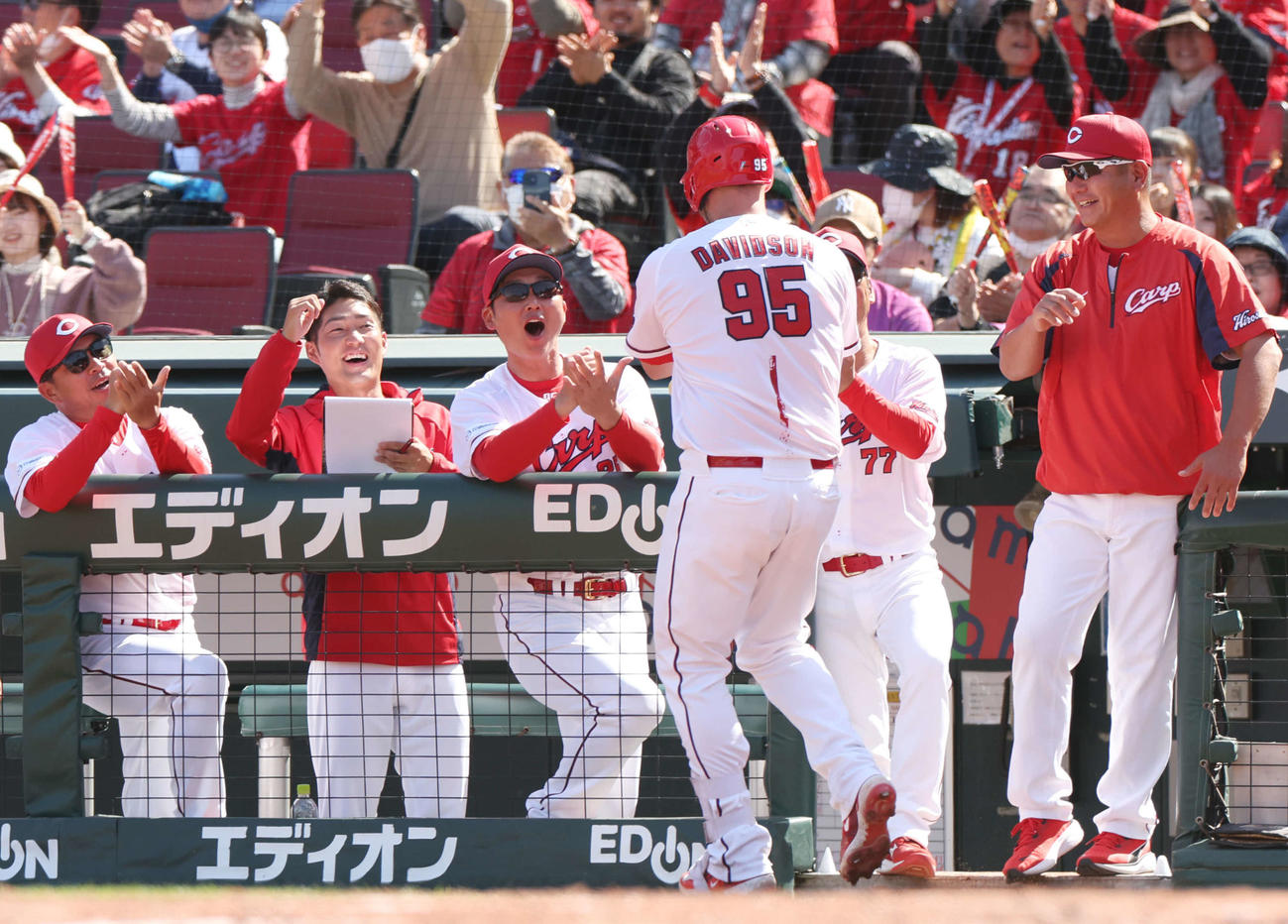 広島対巨人　4回裏広島無死、右越えソロ本塁打を放ったデビッドソン（左から4人目）を迎える新井監督（中央）（撮影・宮地輝）