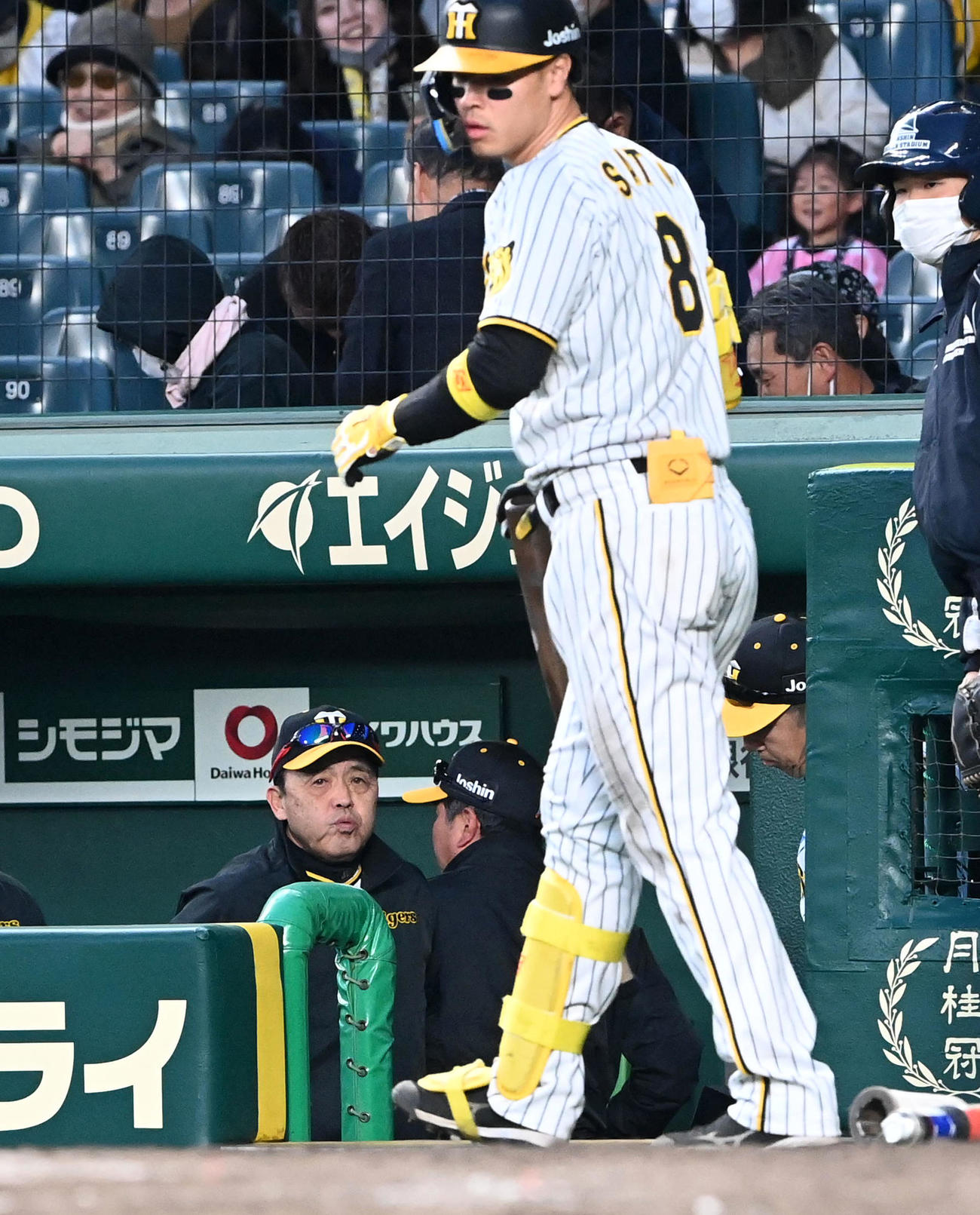 阪神対ヤクルト　ヤクルトと引き分け、あいさつのためベンチを出る岡田監督。手前は佐藤輝（撮影・前岡正明）