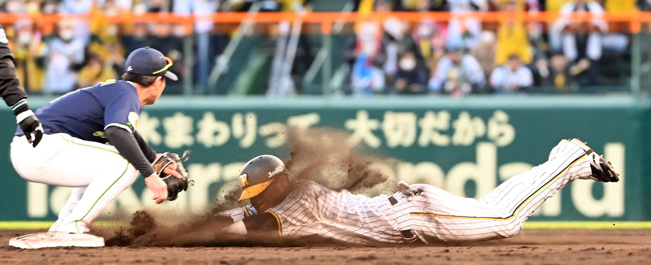 阪神対ヤクルト　11回裏阪神1死、木浪は右翼線に二塁打を放ちヘッドスライディング。遊撃手長岡（撮影・前岡正明）