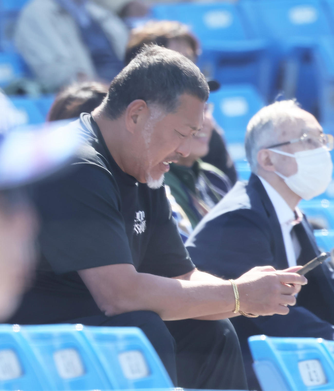 法大対慶大　2回裏慶大2死一塁、清原正吾が左前打を放ちスマートフォンを操作する父和博氏（撮影・足立雅史）