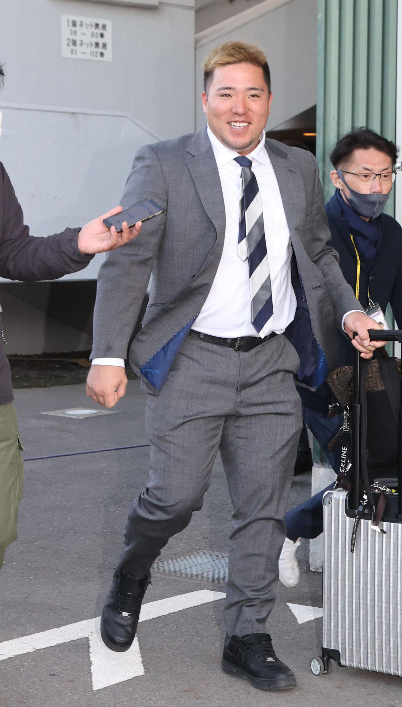 9日、記者の質問に答えながら移動のバスに向かう西武山川