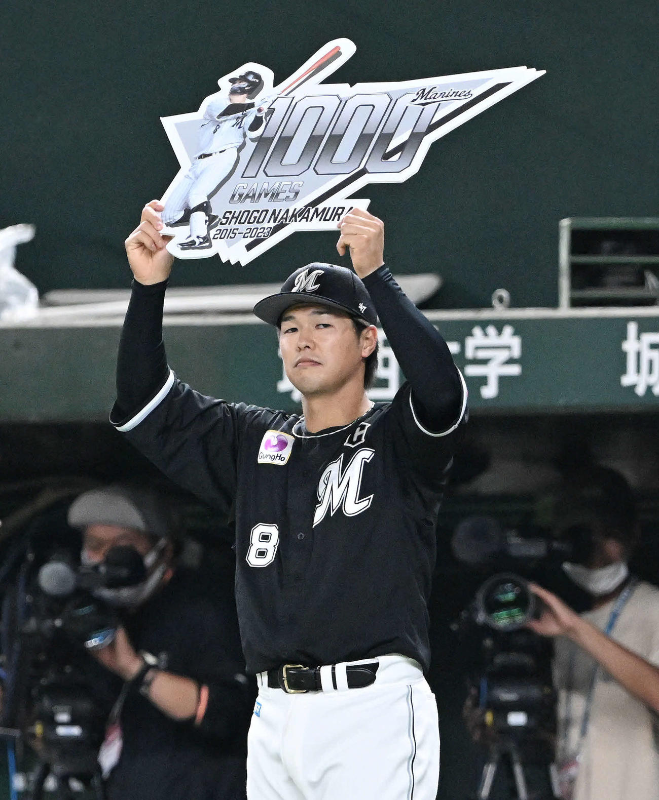 西武対ロッテ　5回裏を終え1000試合出場を達成したロッテ中村奨は記念のパネルを手にする（撮影・滝沢徹郎）