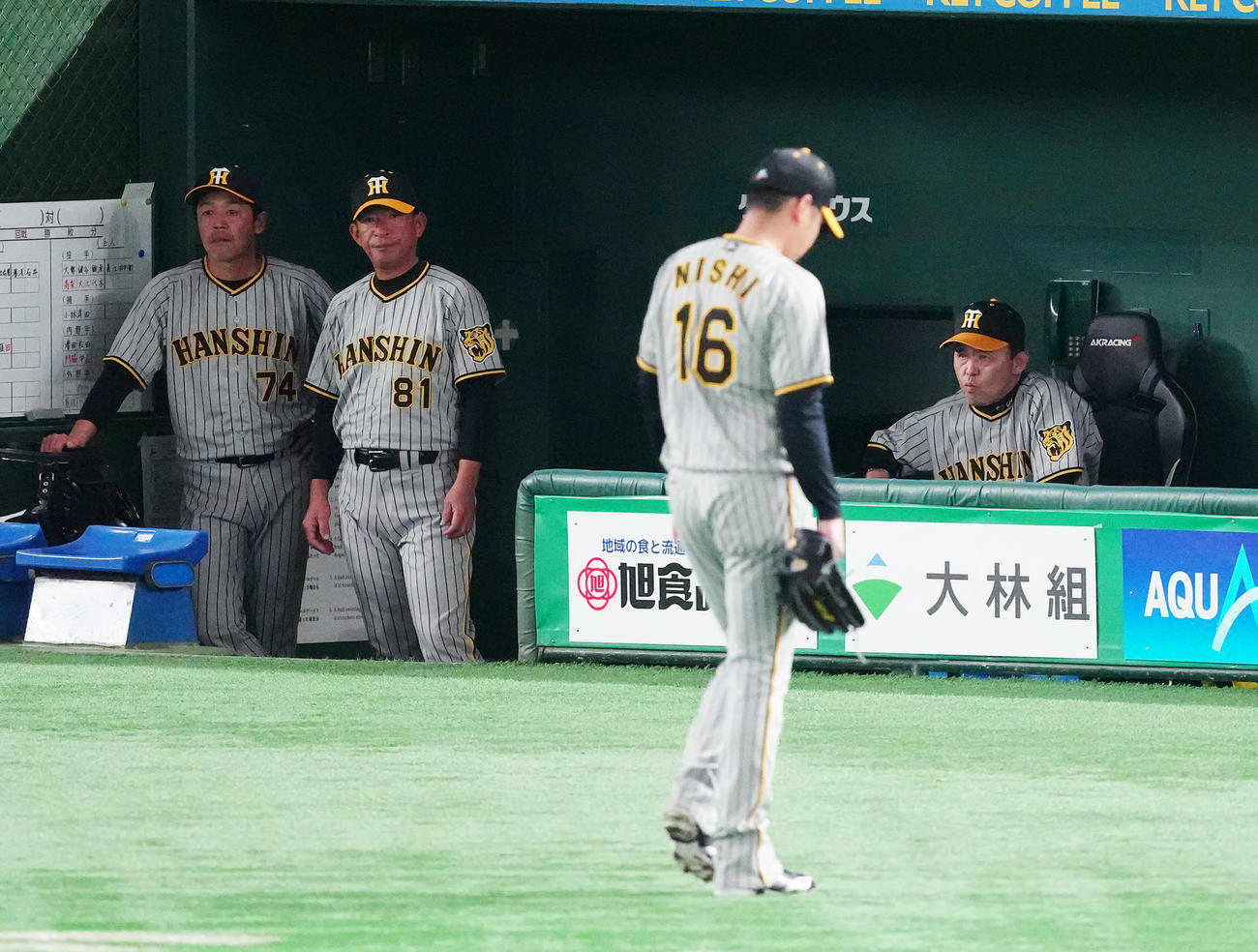 巨人対阪神　7回裏途中で阪神先発西勇（手前）を降板させ、ベンチで厳しい表情の岡田監督（右）（撮影・江口和貴）