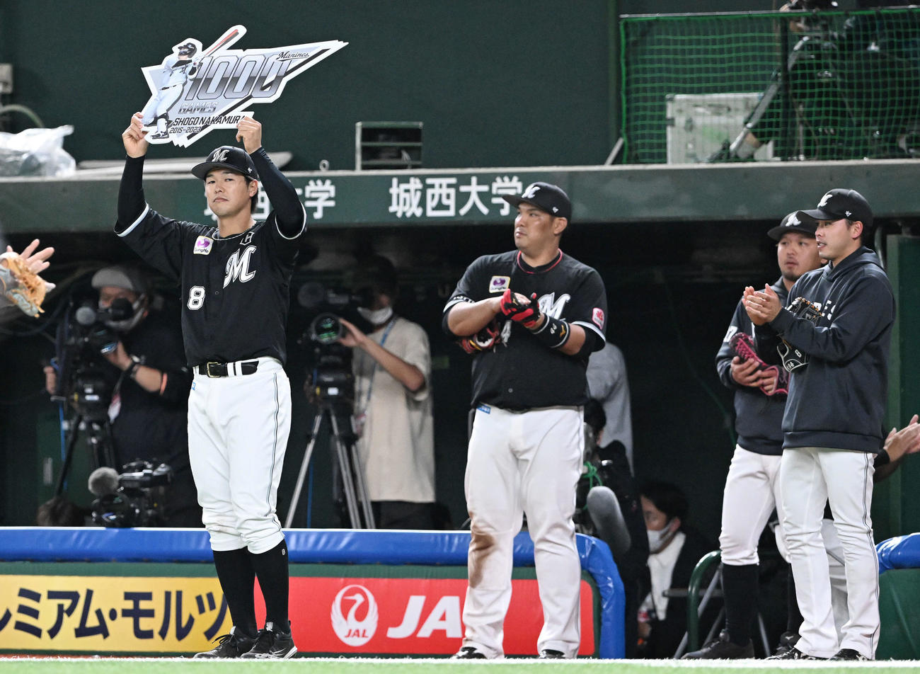 西武対ロッテ　5回裏を終え1000試合出場を達成したロッテ中村奨（左）は記念のパネルを手にする（撮影・滝沢徹郎）